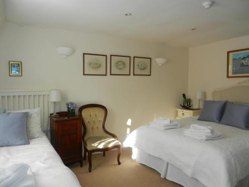 a bedroom with two beds and a chair in it at Brocks in Bath