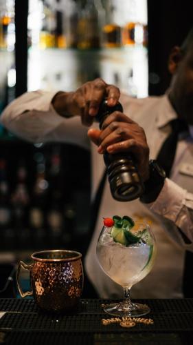 a man pouring a drink into a martini glass at Hugo's Boutique Hotel - Adults Only in St Julian's