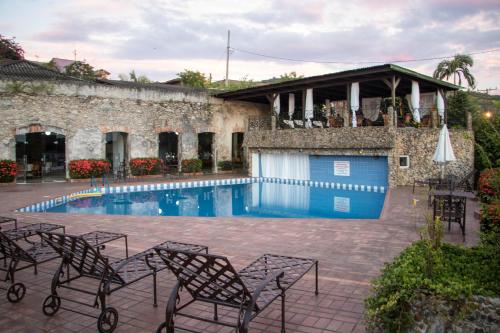 a swimming pool with chairs next to a building at Hotel Camboa Antonina - PR in Antonina