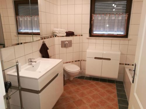 uma casa de banho com um lavatório branco e um WC. em Ferienwohnung Edda em Ebensfeld