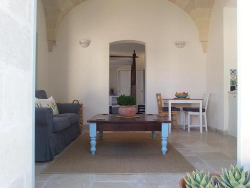 ein Wohnzimmer mit einem Sofa und einem Tisch in der Unterkunft The Proud Garden in Carovigno