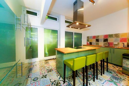 ハイデルベルクにあるConnie's House Holiday Apartmentのキッチン(緑のキャビネット、黄色のスツール付)