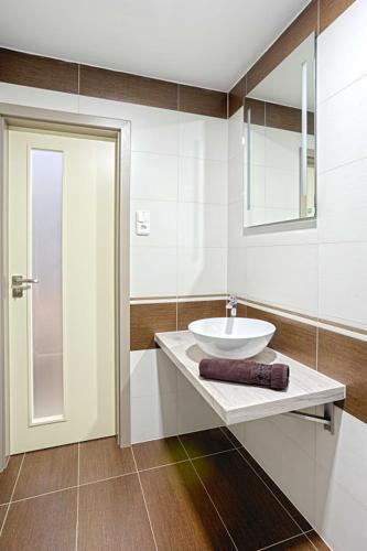 a white bathroom with a sink and a mirror at Šnekolend in Rokytnice nad Jizerou