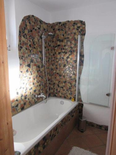 a bath tub in a bathroom with a wall at An der Stadtmauer in Korbach