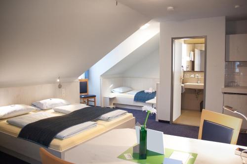 a hotel room with a bed and a desk and a room at Pension Vicus in Passau