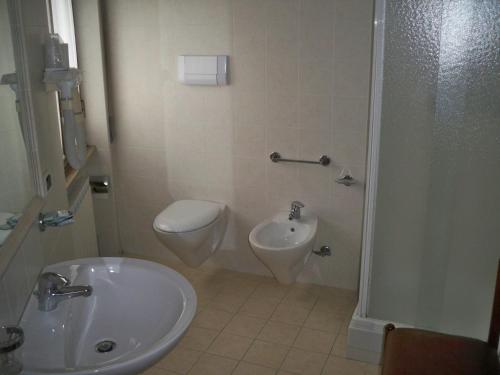 a bathroom with a sink and a toilet and a bidet at Albergo Corradetti in Castel di Sangro