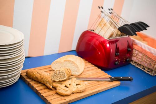 a cutting board with bread and a toaster on a table at La Gustea Hotel & Cucina in Sarteano
