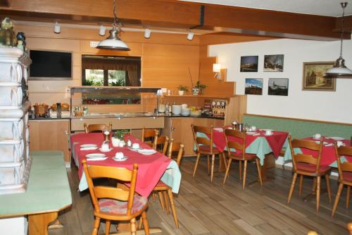 a restaurant with tables and chairs and a kitchen at Hotel Spitzenpfeil in Michelau