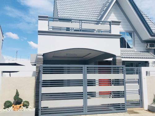 a white house with a gate in front of it at Hillary Timog Park Homes in Angeles