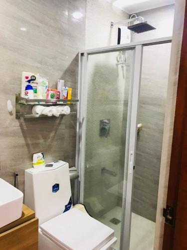 a bathroom with a shower and a toilet at Hillary Timog Park Homes in Angeles