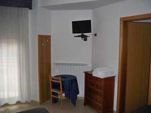 a room with a dresser and a tv on the wall at Albergo Corradetti in Castel di Sangro