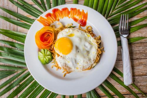 a plate of food with an egg on top of pasta at The Syron Huts Lembongan in Nusa Lembongan