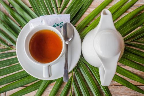 a cup of tea on a plate with a spoon at The Syron Huts Lembongan in Nusa Lembongan