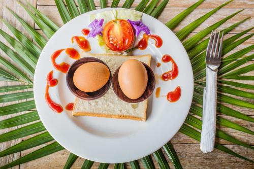 a plate of food with eggs on a sandwich at The Syron Huts Lembongan in Nusa Lembongan