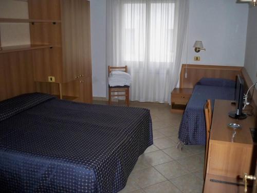 Pokój hotelowy z niebieskim łóżkiem i stołem w obiekcie Albergo Corradetti w mieście Castel di Sangro