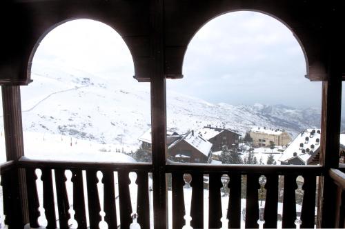 a view of a snow covered mountain from a window at Hotel GHM Monachil in Sierra Nevada