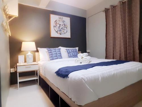 a bedroom with a bed with a blue accent wall at Baan Pinklao in Bangkok