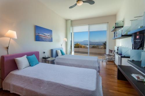 Una habitación de hotel con dos camas y un televisor. en Antiopi Luxury Villa, en Agia Pelagia