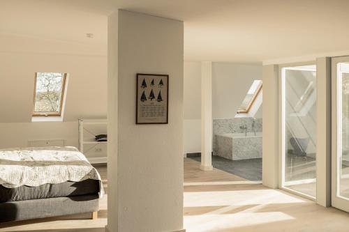 a white bedroom with a bed and a bathroom at Gutshaus Üselitz in Poseritz