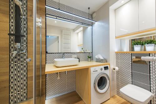 a bathroom with a sink and a washing machine at P&O Apartments Służewiec in Warsaw