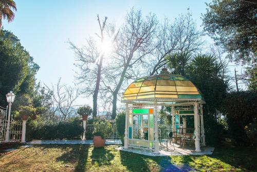 un cenador en un patio con el sol brillando en B&B Casale dell'Insugherata, en Roma