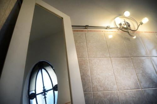 a bathroom with a mirror and a window and a light at Casa Mutante Hostel in Montevideo