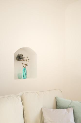 a white couch with a vase of flowers on a wall at Gutshaus Üselitz in Poseritz