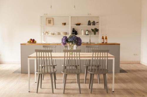 a kitchen with a table with chairs and a vase of flowers at Gutshaus Üselitz in Poseritz