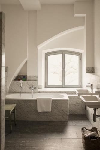 a bathroom with a large tub and a window at Gutshaus Üselitz in Poseritz