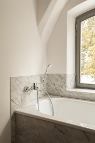 a bath tub in a bathroom with a window at Gutshaus Üselitz in Poseritz