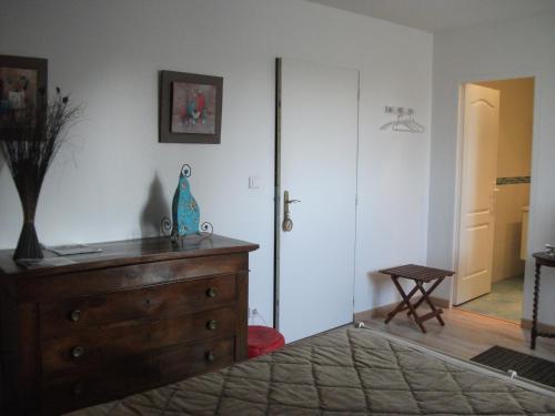 a bedroom with a dresser and a door with a table at Le Moulin De Laval in Cuisy-en-Almont