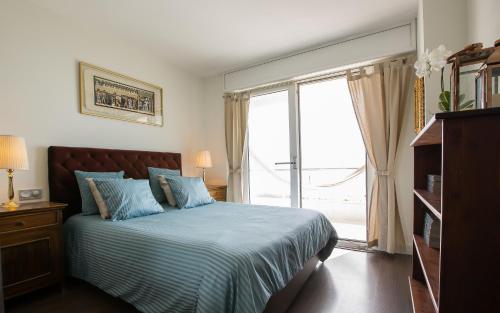 een slaapkamer met een bed en een groot raam bij Gava Beach 1st Line in Gavà