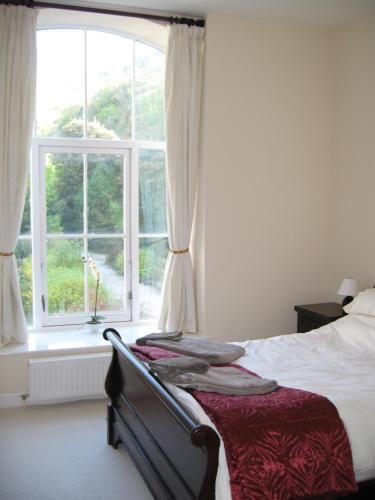 a bedroom with a bed and a large window at Litton Mill Apartment in Tideswell