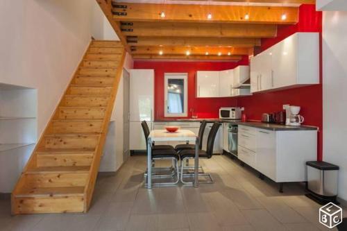 a kitchen with a table and a staircase in a room at Gîte Domaine Bastide Jourdan in Bollène