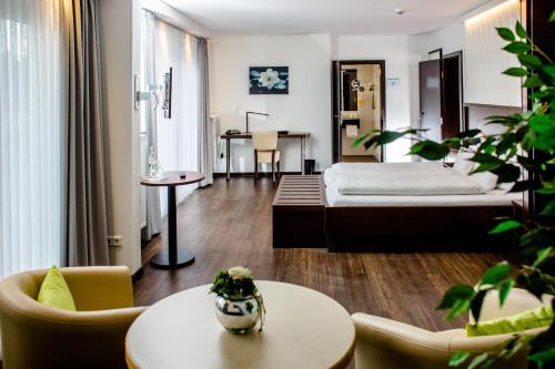 Habitación de hotel con cama, mesas y sillas en Hotel Bolte, en Salzbergen