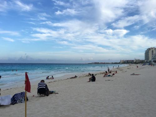 a group of people sitting on the beach at Cancun Plaza - Best Beach in Cancún