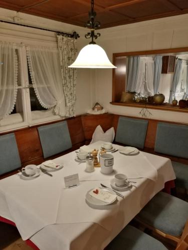 a dining room with a white table and chairs and a light at Herzen´s Landhaus in Hirschegg