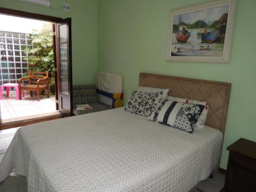 Un dormitorio con una cama con almohadas encima. en ACIOLY'S BEACH HOUSE, en Caraguatatuba