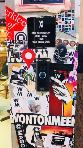 a collage of stickers on a wall with a camera at Wontonmeen in Hong Kong