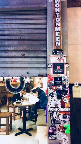 a restaurant with a table and people sitting at a table at Wontonmeen in Hong Kong