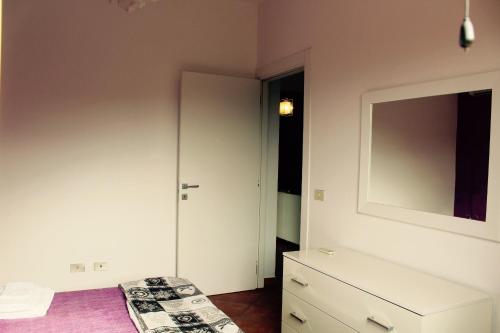 Un dormitorio con una cama, una cómoda y un espejo. en Villa Aga, en Campofelice di Roccella
