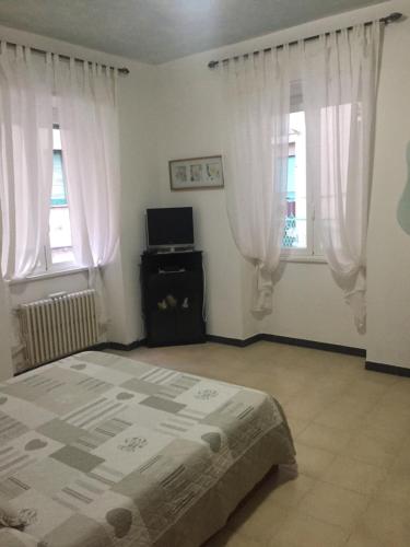 a bedroom with a bed and two windows at Miky House in Rapallo