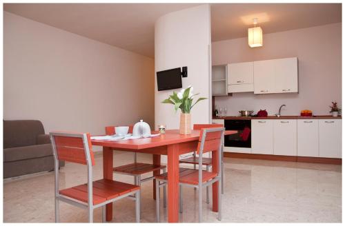 cocina y comedor con mesa de madera y sillas en Appartamenti Sant' Andrea, en Trapani