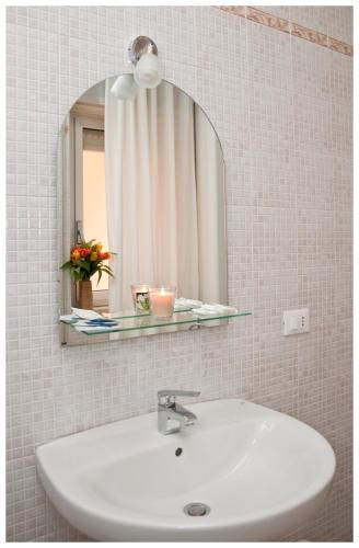 a white sink in a bathroom with a mirror at Appartamenti Sant' Andrea in Trapani