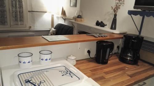 uma cozinha com um fogão e um balcão com um lavatório em L'Estacade : maison de pecheur em Saint-Valery-sur-Somme