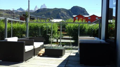 a dog laying on a balcony with a view of mountains at Kau Si Aike in El Chalten