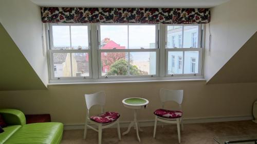 a living room with a window and two chairs and a table at Spetchley House in Tenby