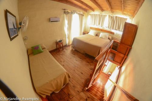 een slaapkamer met een bed en een trap in een kamer bij De Luna in Puerto Pirámides