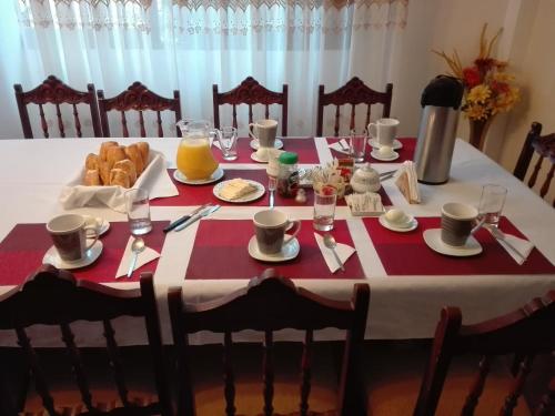 a table with a red and white table cloth with food on it at Apart & Hostal ManuAlé in Tacna