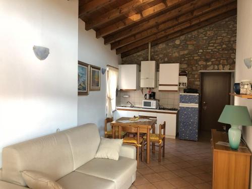 ein Wohnzimmer und eine Küche mit einem Sofa und einem Tisch in der Unterkunft Casa Nadia in San Zeno di Montagna